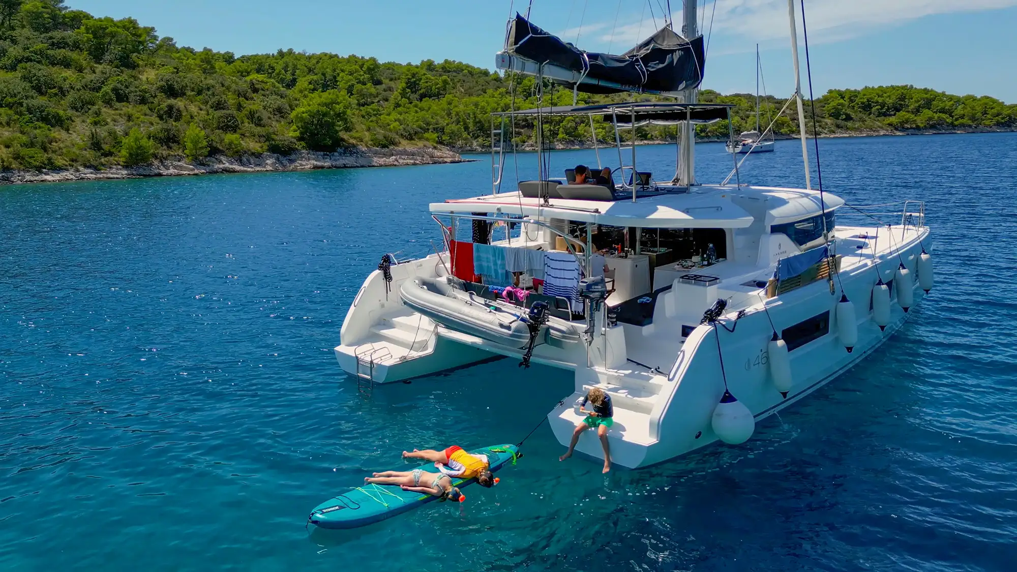 Catamaran on the sea with water board near the island