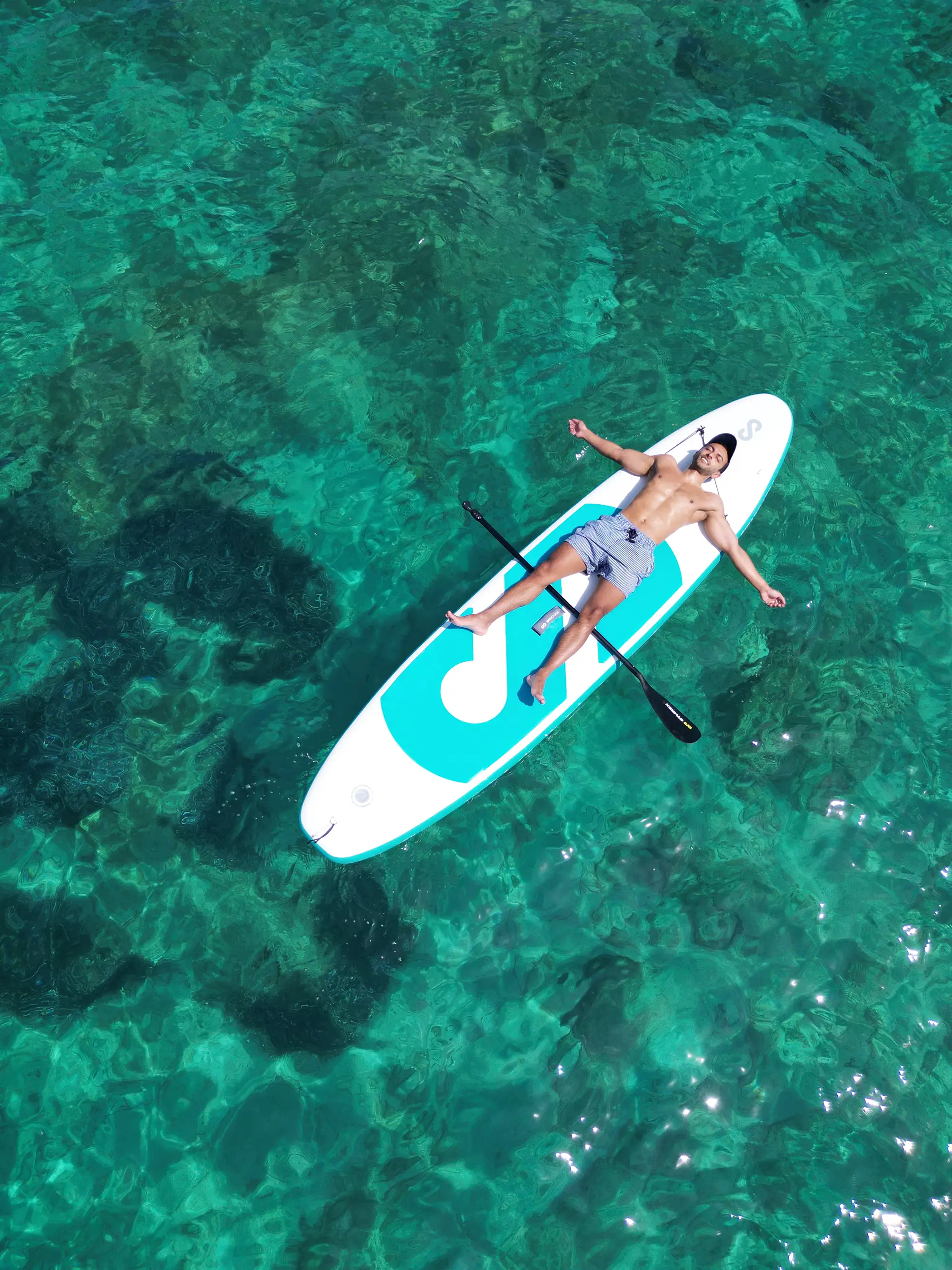 Man enjoying the sun on the water peddling board