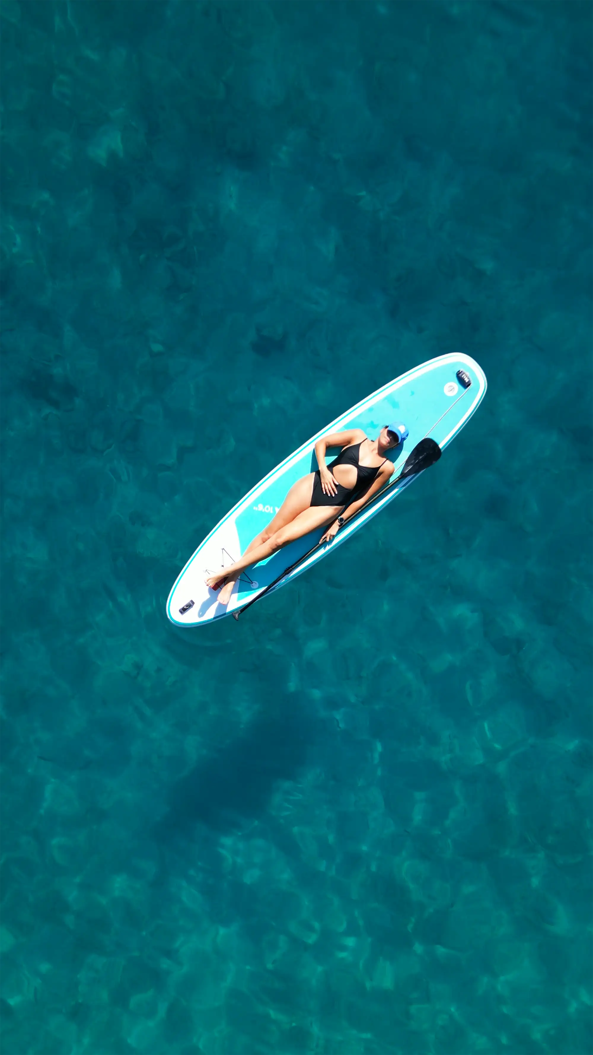 Pretty woman enjoying the sunbathing on the water board