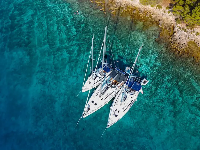 Three sailboats docked together