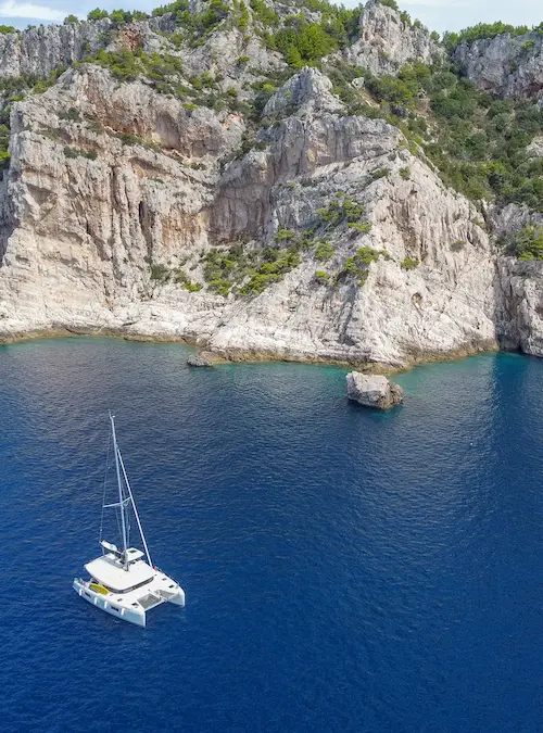 Catamaran in the sea near a cliff