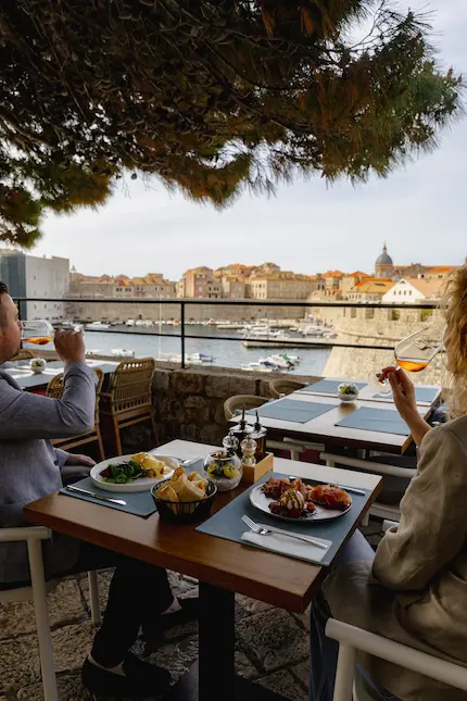 Two people enjoying glass of wine with view to Dubrovnik city