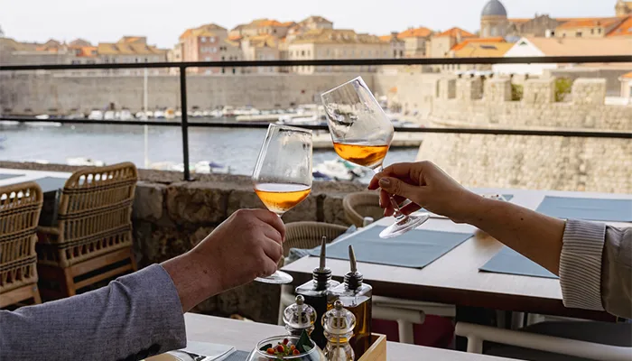 Cheering with glass of wine next to the sea