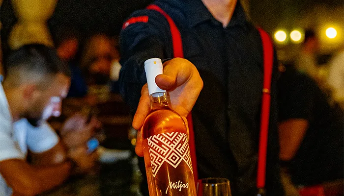 Waiter serving bottle of wine